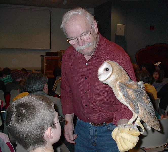 boy taking a close look at an owl during nature program